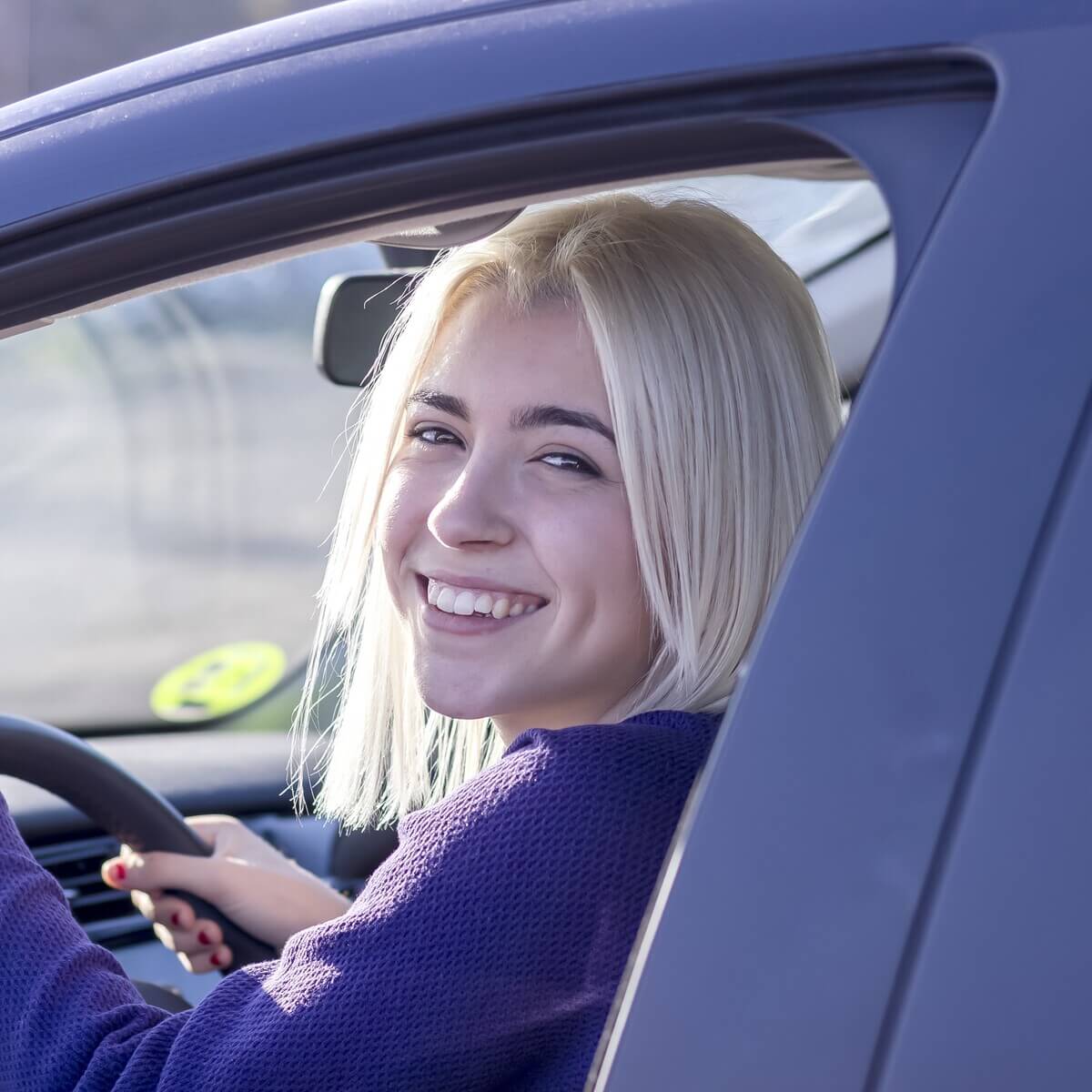 young smiling woman steering car at sunset KV92T9C safedriver beograd